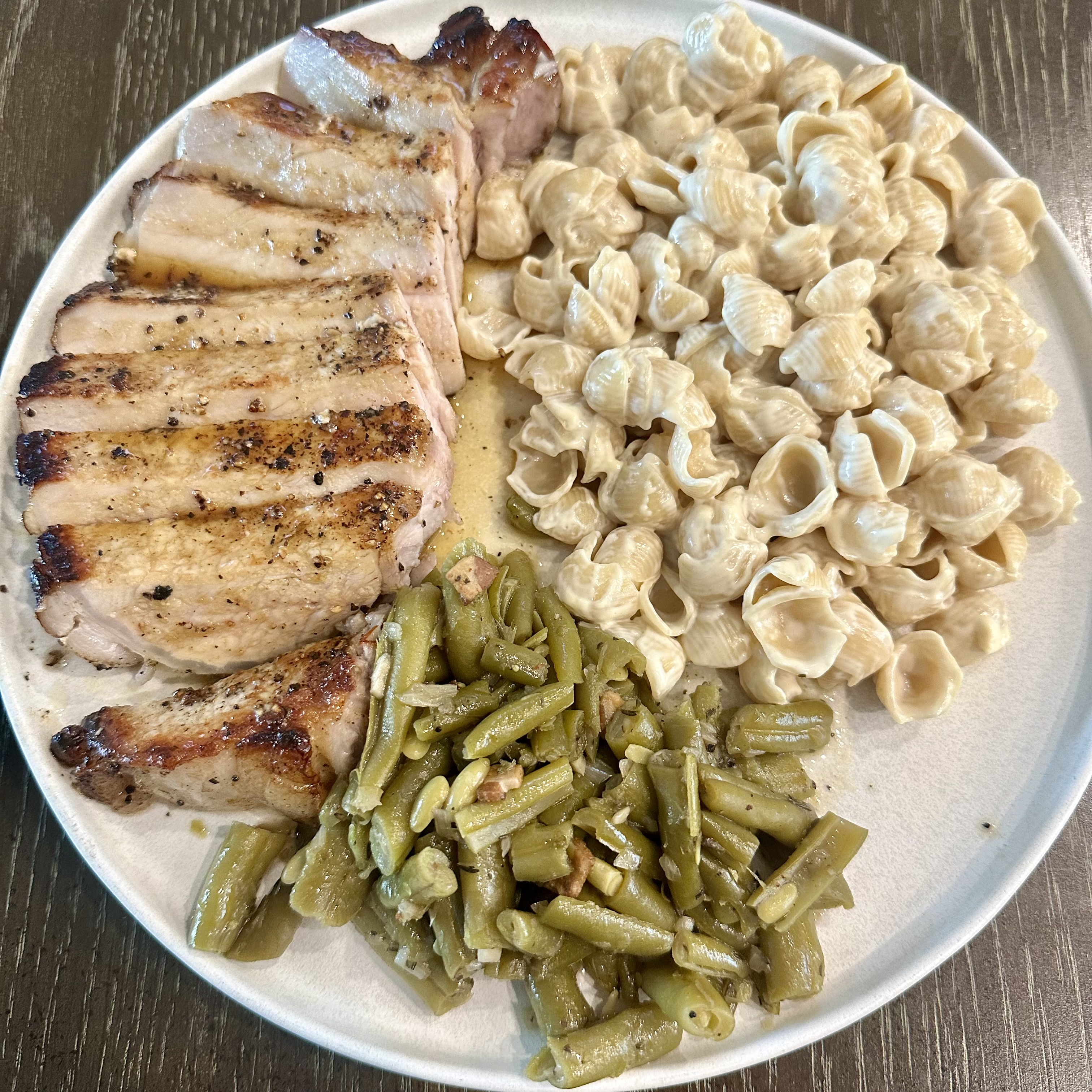 Overstuffed plate of pork chop with agridolce, goodles, and green beans