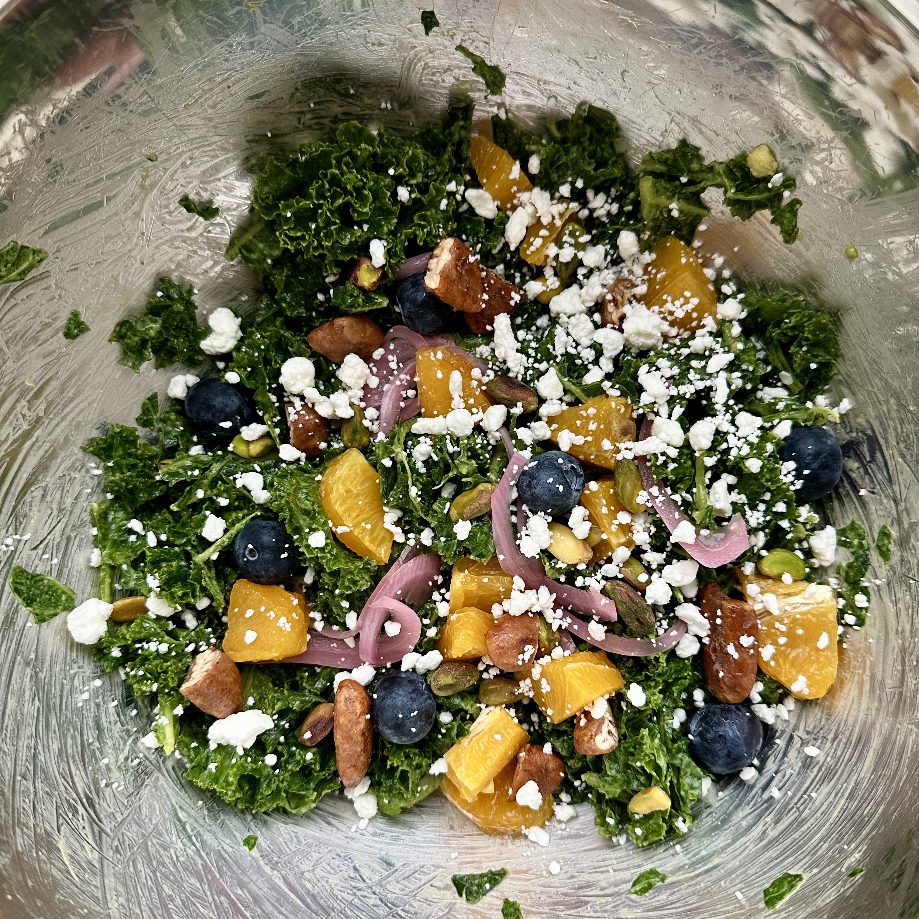 Kale salad massaged with avocado, fresh orange slices, jumbo blueberries, bland pistachios, sweet honey pecans, goat cheese crumbles, and Defined Dish salad dressing