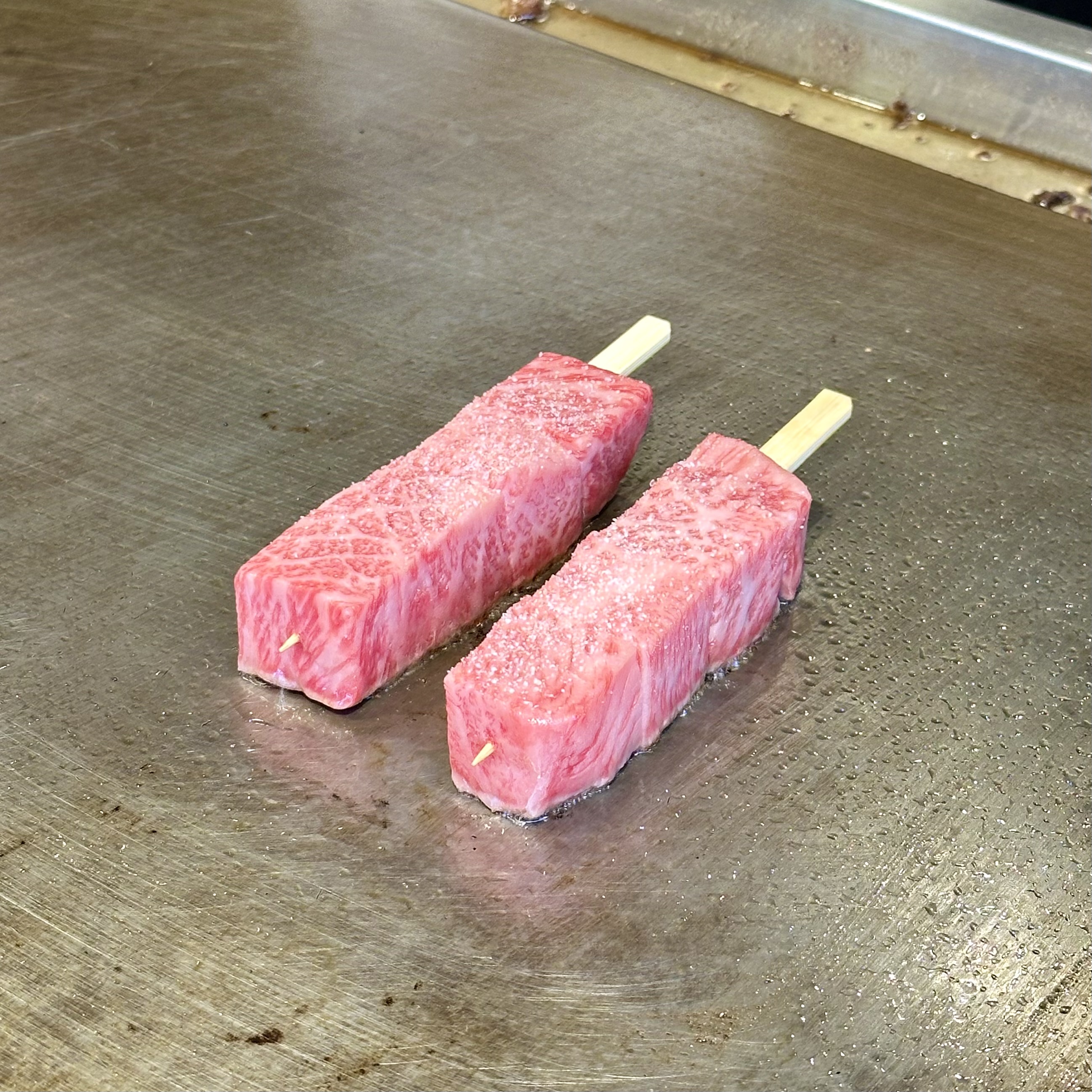 A5 Wagyu skewer being grilled at Tsujiki Market in Tokyo